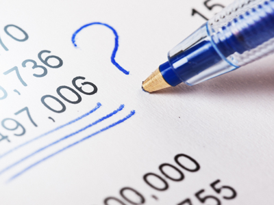 Ballpoint puts question mark by figures on financial document