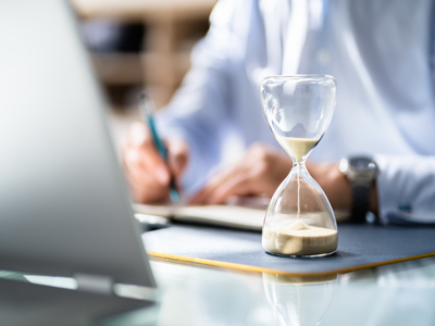 Businessperson's Hand Calculating Invoice In Office